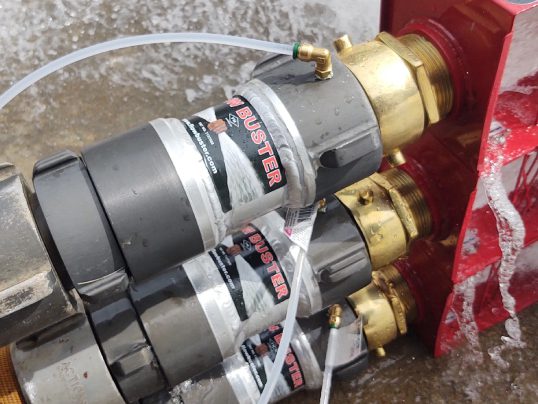 Two gray pumps with brass hose fittings